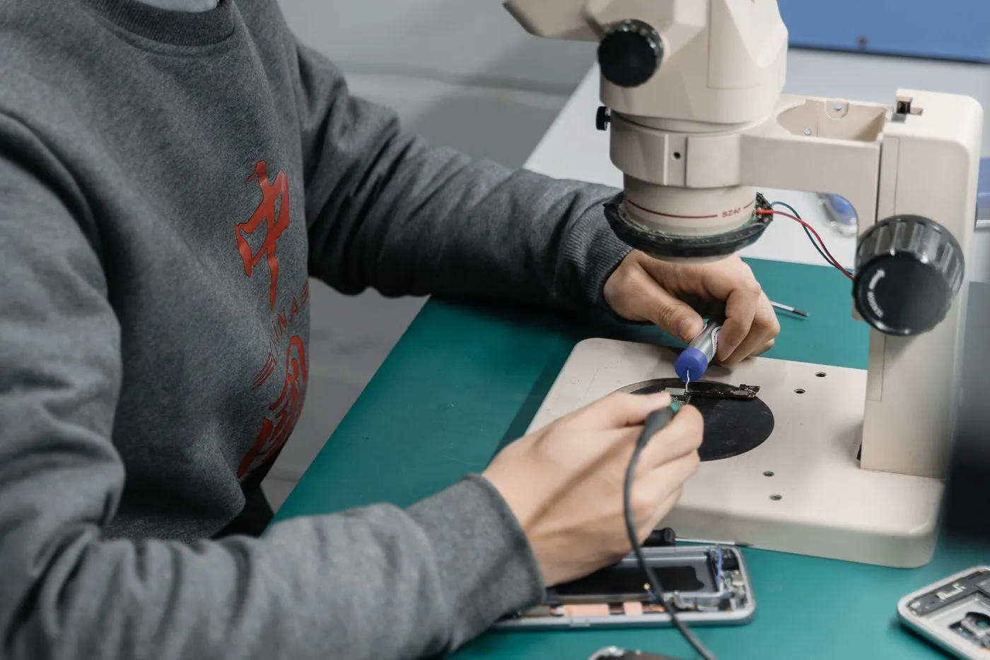 Technician working on a phone repair at a workbench